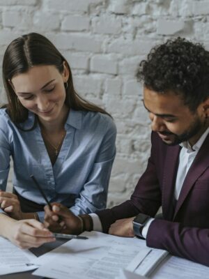 Two business professionals collaborating on documents in an office setting.
